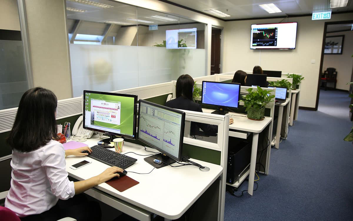 oficina en el que varias personas trabajan en el ordenador analizando ratios económico-financieros de empresas