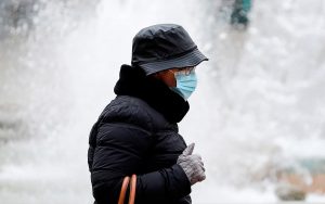 Una mujer se protege del frío hoy en la capital valenciana