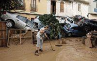 Vecina de Paiporta limpiando el barro. (EFE Biel Aliño)